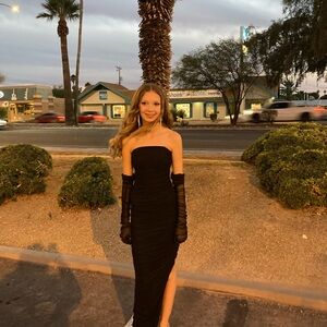 Black floor length strapless formal dress. Full length sheer black gloves.